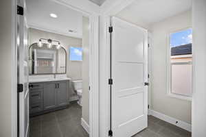 Half bathroom featuring vanity, dark tile patterned flooring, and recessed lighting