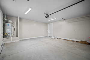 Garage featuring water heater and baseboards