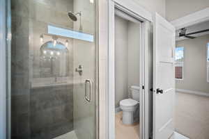 Full bathroom with a shower stall and a ceiling fan