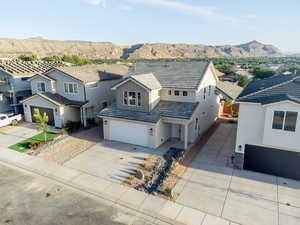 Traditional-style house with driveway, stucco siding, a residential view, a mountain view, and a garage