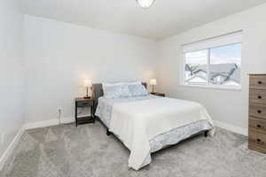 Bedroom with light carpet and baseboards