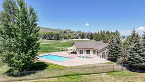 View of pool with a patio area, a sunroom, and view of wooded area