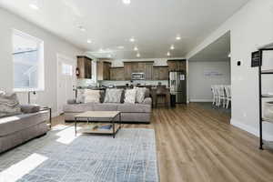 Living room with light wood-type flooring and recessed lighting