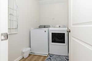 Washroom featuring washer and dryer and light wood-style floors