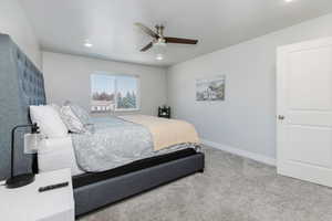 Carpeted bedroom with a ceiling fan and recessed lighting
