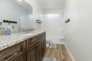 Full bathroom with vanity, shower / tub combo with curtain, light wood-type flooring, and a chandelier