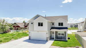 View of front of home featuring stone siding, roof with shingles, a garage, and driveway