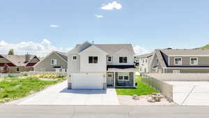 Modern farmhouse with an attached garage, stone siding, driveway, a residential view, and board and batten siding