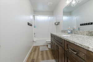 Full bathroom featuring shower / bath combo, vanity, light wood finished floors, and a chandelier