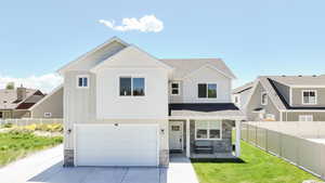 View of front of house with stone siding, a garage, concrete driveway, and board and batten siding
