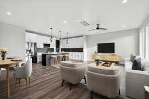 Living area with dark wood-type flooring, a ceiling fan, and recessed lighting