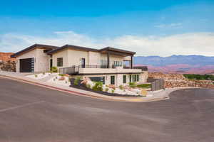 Contemporary home featuring a balcony, a mountain view, stucco siding, a garage, and a tile roof