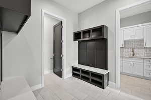 Mudroom with baseboards and a sink