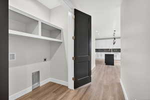 Downstairs ADU. Washroom with light wood-style floors and washer hookup