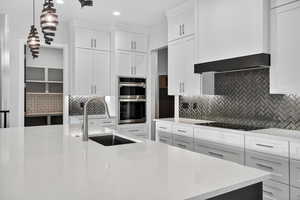 Kitchen with decorative backsplash, white cabinetry, light stone counters, and recessed lighting