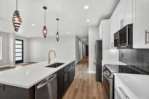Downstairs ADU. Kitchen featuring appliances with stainless steel finishes, white cabinets, hanging light fixtures, and recessed lighting