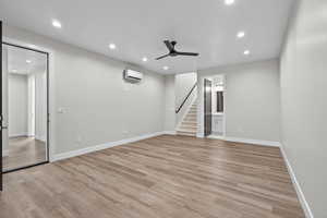 Basement featuring recessed lighting, ceiling fan, light wood-type flooring, and stairway