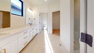 Full bathroom featuring double vanity, a shower, and light marble finish floors