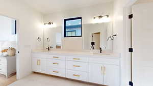 Bathroom featuring double vanity and light marble finish flooring