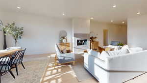 Living room featuring recessed lighting, light wood-style floors, and a tile fireplace