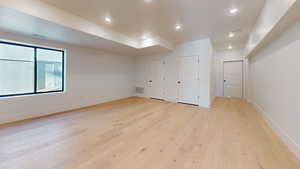 Additional living space with light wood-style flooring and recessed lighting