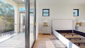 Bedroom with light wood finished floors and access to outside