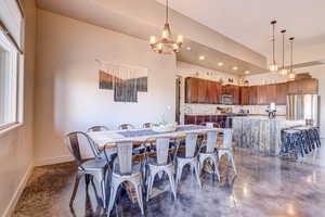 Dining area featuring recessed lighting, concrete flooring, and a chandelier