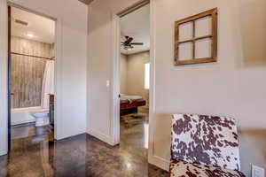 Bathroom with shower / tub combo with curtain, a ceiling fan, and finished concrete flooring