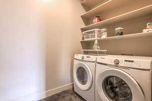 Laundry area with baseboards and washer and dryer