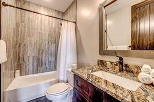 Bathroom with shower / bath combination with curtain and vanity