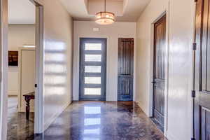 Foyer entrance featuring baseboards and finished concrete flooring