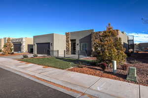 View of front facade featuring stucco siding, a garage, and driveway