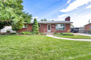 Single story home featuring brick siding and a chimney