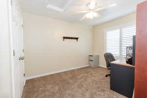 Home office featuring light carpet and a ceiling fan