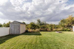 View of yard with a shed and a fire pit