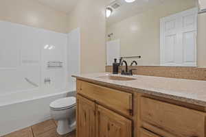Bathroom featuring vanity, light tile patterned flooring, and  shower combination