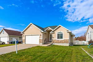 View of front of property featuring stucco siding, concrete driveway, stone siding, and a garage