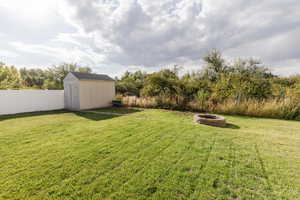View of yard with a storage shed and a fire pit