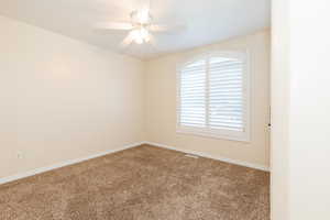 Empty room with carpet and a ceiling fan