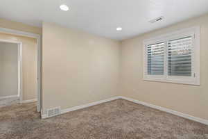 Carpeted empty room with baseboards and recessed lighting