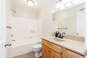 Full bathroom featuring washtub / shower combination, light tile patterned floors, and vanity