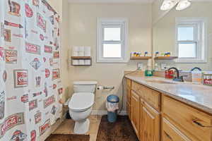 Full bath with a shower with shower curtain, vanity, and dark tile patterned floors