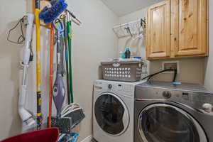 Washroom featuring cabinet space and separate washer and dryer