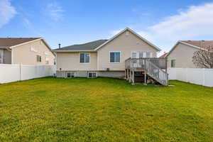 Back of property with a fenced backyard, stairway, and a wooden deck