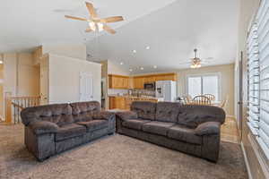 Living area featuring a ceiling fan, light colored carpet, high vaulted ceiling, and recessed lighting