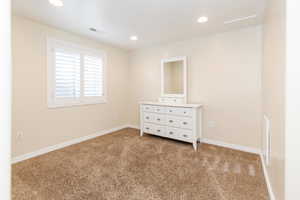 Unfurnished bedroom featuring carpet, recessed lighting, and attic access
