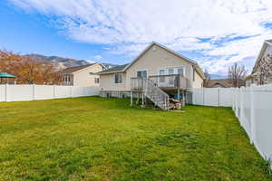 Rear view of house with stairs, a fenced backyard, and a wooden deck