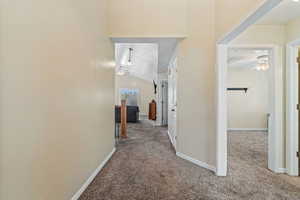 Hall with carpet floors and lofted ceiling