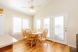 Dining area featuring light wood-style floors, lofted ceiling, and ceiling fan