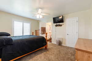 Bedroom featuring carpet floors, a ceiling fan, and ensuite bathroom